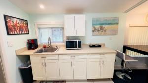a kitchen with a sink and a microwave at Billy's Resort- Men Only - Solo Hombres in Wilton Manors