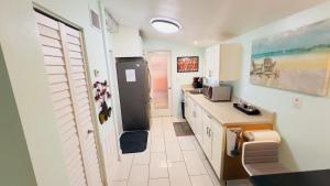 a kitchen with a counter and a refrigerator in it at Billy's Resort- Men Only - Solo Hombres in Wilton Manors
