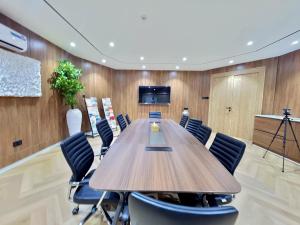 a conference room with a large wooden table and chairs at Amazonia Luxury in Abuja