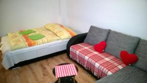 una habitación con sofá y una cama con corazones. en Apartment LULU, en Štrbské Pleso
