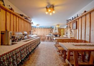 a restaurant with wooden tables and chairs in a room at Dom Wypoczynkowy Skorusa in Białka Tatrzańska