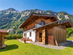 a barn with a table and chairs in front of a mountain at Barney in Rauris