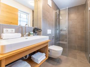 a bathroom with a sink and a shower at Chalet Aquila in Niedernsill +35 photos