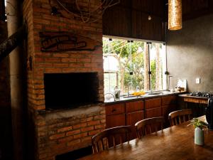 a kitchen with a brick fireplace and a table with chairs at Recanto da Cuesta in Botucatu