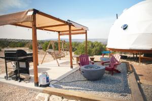 a dome tent with chairs and a grill and a grill at Dome on the Range in Duchesne