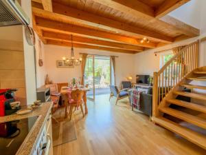 a kitchen and living room with wooden ceilings and a staircase at Kötschach in Kötschach