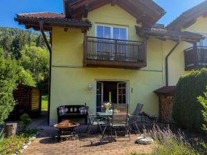 a house with a balcony and a table and chairs at Kötschach in Kötschach