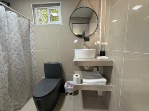 a bathroom with a toilet and a sink and a mirror at El Mangal 4 B&B in Suchitoto
