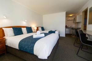 a hotel room with a large bed and a kitchen at Waves on Banyan formerly Comfort Inn International in Warrnambool