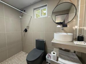 a bathroom with a sink and a toilet and a mirror at El Mangal 4 B&B in Suchitoto