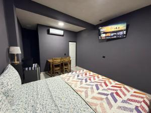 a bedroom with a bed and a tv on the wall at El Mangal 4 B&B in Suchitoto