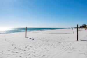 a volleyball net on a beach with the ocean at Sea Oats Motel in Destin