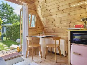 a small kitchen with a table and chairs in a tiny house at Tiny House Jet in Goedereede