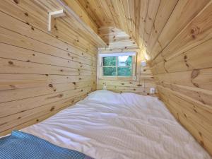 a bedroom in a log cabin with a bed in it at Tiny House Jet in Goedereede
