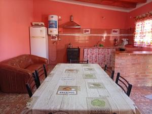 a kitchen with a wooden table and a refrigerator at Maimara Hospedaje Sumalawa in Maimará