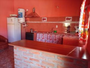 a kitchen with a brick counter and a refrigerator at Maimara Hospedaje Sumalawa in Maimará