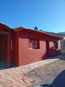 a red house with two windows and a roof at Maimara Hospedaje Sumalawa in Maimará