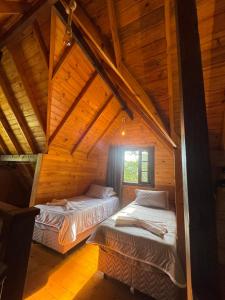 two beds in a cabin with wooden ceilings at Cabanas em Canela - Leão da Tribo de Judá- Refúgio com Piscina in Canela +108 photos