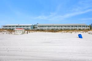 a building on the beach with a blue bucket in the sand at Sea Oats Motel in Destin