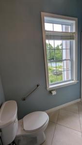 a bathroom with a toilet and a window at Happy Moose Guest Suite in Porters Lake +18 photos