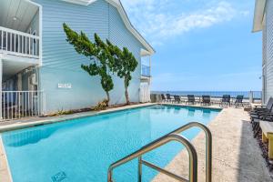 a swimming pool with chairs next to a building at Sea Oats Motel in Destin +7 photos