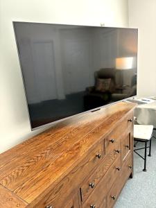 a large flat screen tv on top of a wooden dresser at Bristol Suites in Bristol