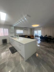 a kitchen with a white island in a living room at Beachfront Haven - Perfect for Groups in Ashdod