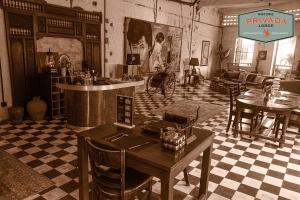 a living room with a table and chairs in a room at Privada Lodge - Historic Hotel in Kratie