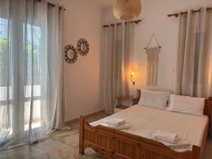 a bedroom with a bed with white sheets and a window at Creta Sun Apartments in Makrigialos Sea-view in Makry Gialos