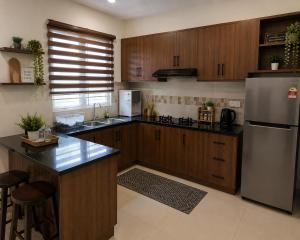a kitchen with wooden cabinets and a stainless steel refrigerator at Kalimero Homestay in Pančevo