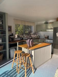a kitchen with a wooden island with stools in it at Travellers Rest Bicheno in Bicheno