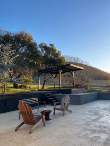 a group of chairs sitting on a patio with a pavilion at Travellers Rest Bicheno in Bicheno