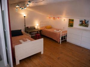 a small bedroom with two beds and a table at Authentique maison de village à Agde avec patio in Agde