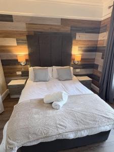 a bedroom with a large white bed with two lamps at Taldrwst At Dwyran in Dwyran