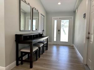 a dining room with a table with chairs and a mirror at Jupiter Heated Pool/Spa Luxury 3Bed Home in Jupiter