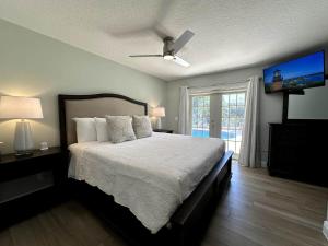 a bedroom with a bed and a flat screen tv at Jupiter Heated Pool/Spa Luxury 3Bed Home in Jupiter +38 photos