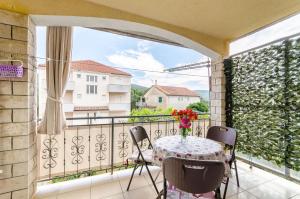 a balcony with a table with a vase of flowers on it at Apartments Emmas studio in Stari Grad +17 photos