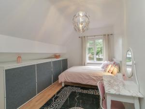 a bedroom with a bed and a table and a window at 59 Nursery Avenue in Coleraine