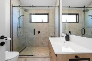 a bathroom with a shower and a toilet and a sink at Roam Taupo Upper Terrace Unit 3 - Spa Pool in Taupo +56 photos