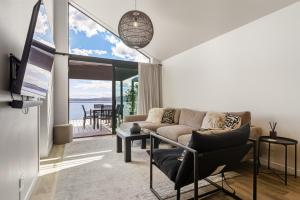 a living room with a couch and a tv at Roam Taupo Upper Terrace Unit 3 - Spa Pool in Taupo