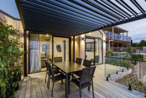 a patio with a table and chairs on a deck at Roam Taupo Upper Terrace Unit 3 - Spa Pool in Taupo