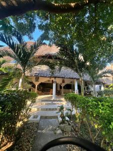 a building with trees and a pathway in front of it at Mepoho Beach Villa Watamu in Watamu