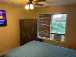 a bedroom with a bed and a tv and a window at Guest Suites in Conley