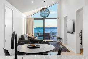 a living room with a table and a view of the ocean at Roam Taupo Lake Front Unit 2 - Spa Pool in Taupo