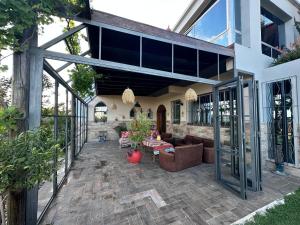 an outdoor patio with a couch and tables and windows at jnan Lemonie in Asilah