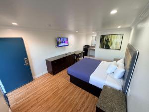 a hotel room with a bed and a flat screen tv at BELL RESORT MOTEL in Bell