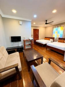 a living room with two beds and a tv at Rivora Gopeng in Gopeng
