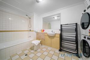 a bathroom with a tub and a toilet and a sink at Perth CBD Hideaway Walk to Everything in Perth