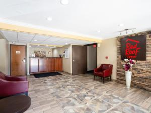 a lobby with a red rock inn sign and chairs at Red Roof Inn Binghamton North in Binghamton