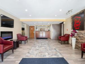 a lobby with red chairs and a waiting room at Red Roof Inn Binghamton North in Binghamton